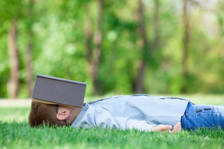 young boy with a book slipping