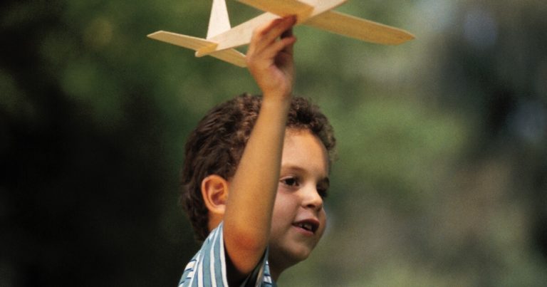 convention-busy toddler- boy flying wooden airplane