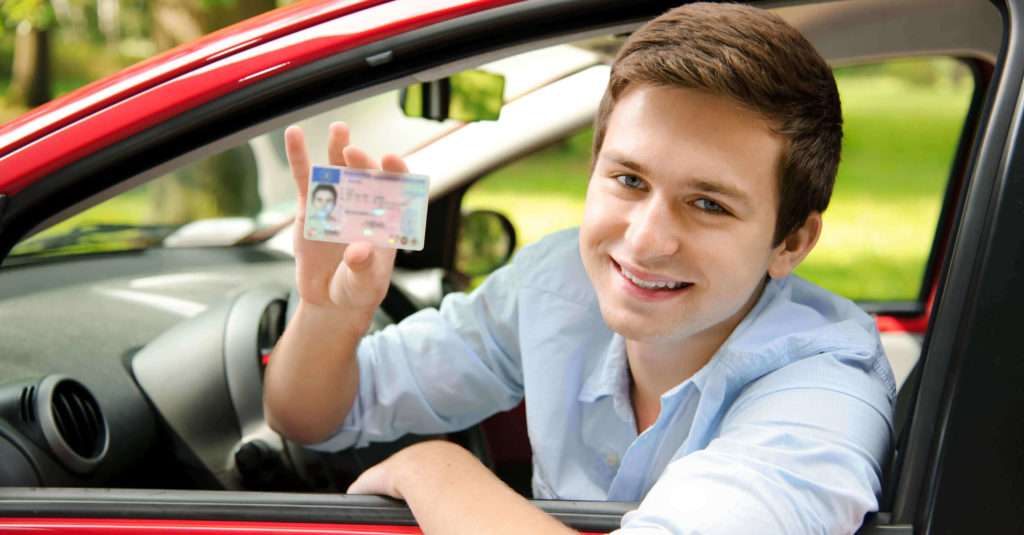 teen student Young man holding drivers license in car Driver Education