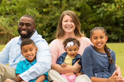 mixed race family sitting and smiling
