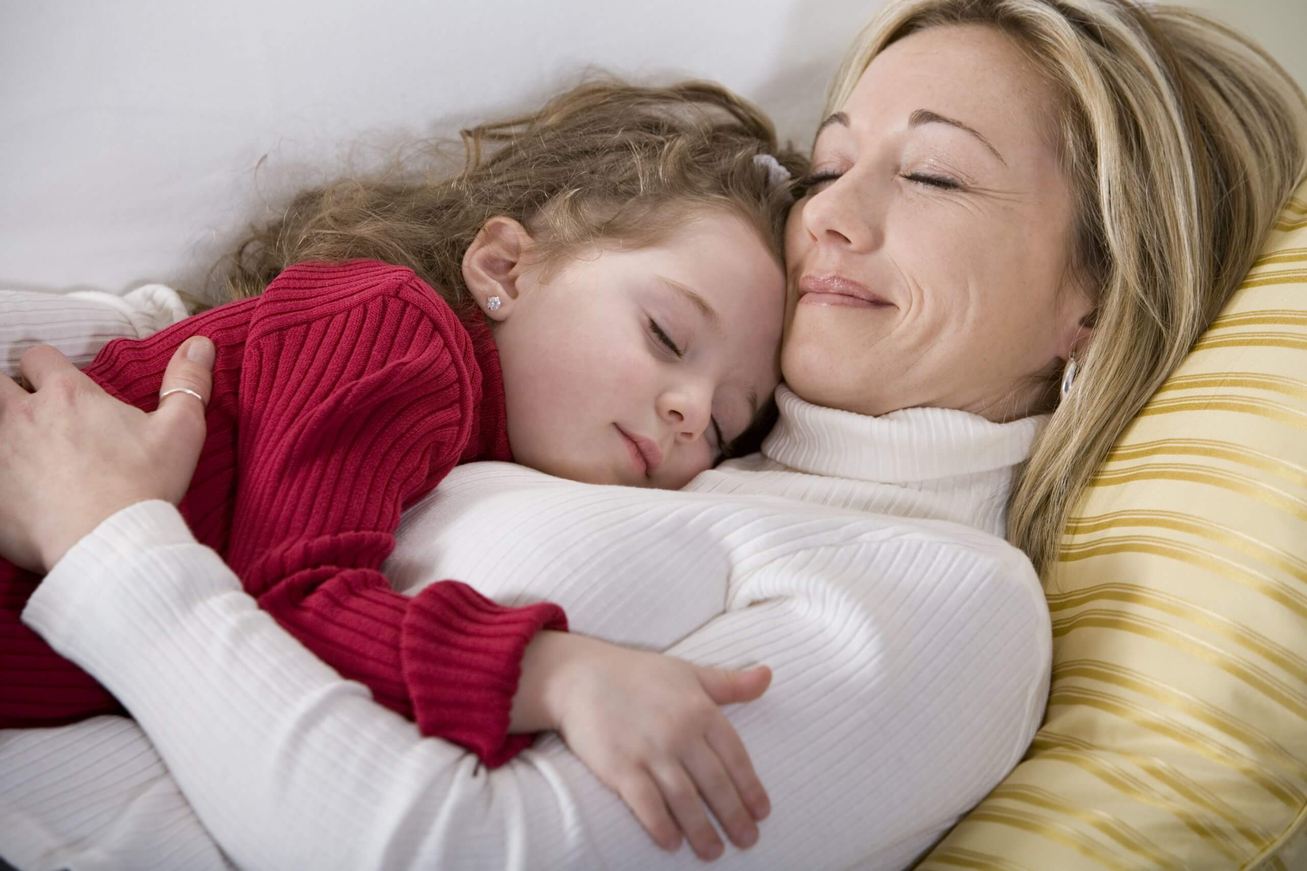nurturing- mom and daughter hugging on sofa