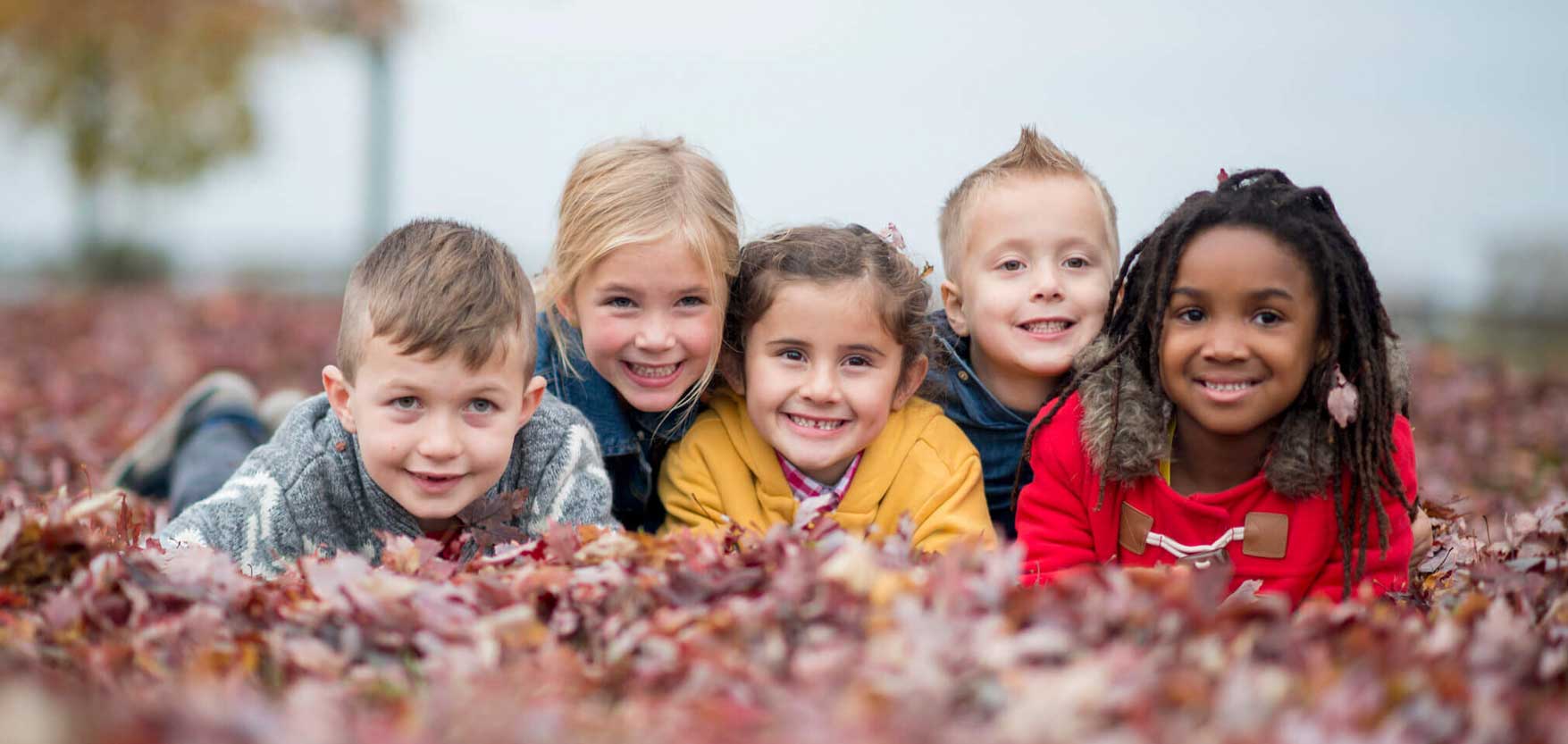 children kids group in leaves at fall